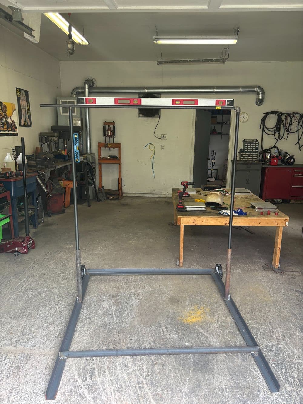 Metal workstand with level and various tools in a workshop environment.